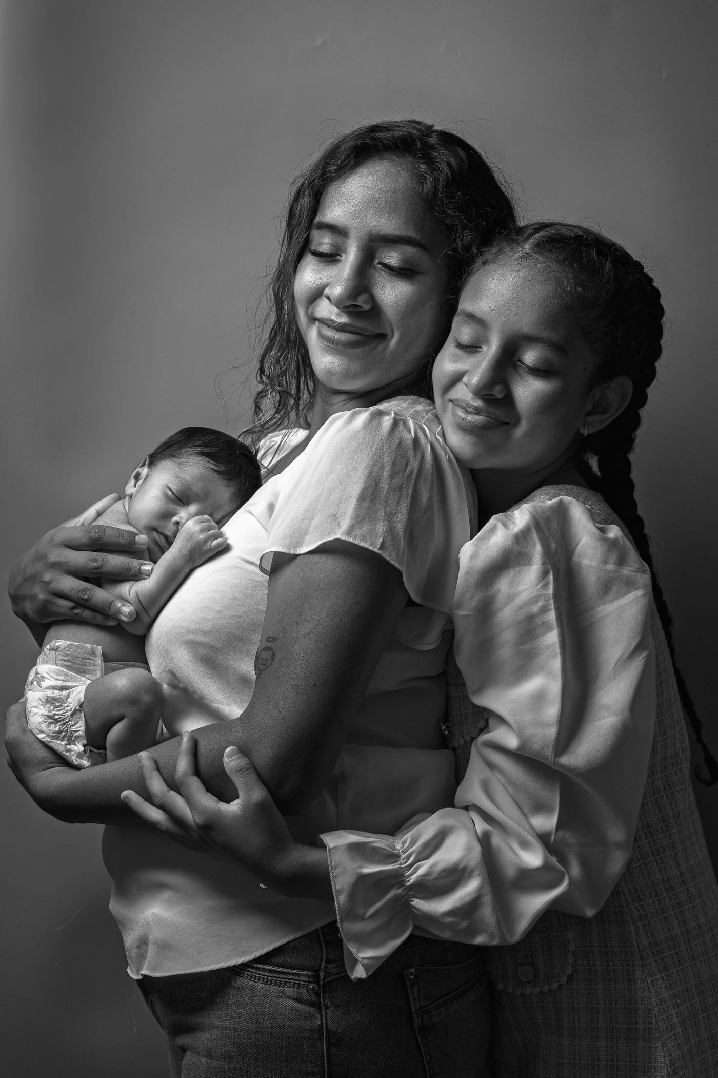 Madre con sus hijos y el recién nacido, en blanco y negro