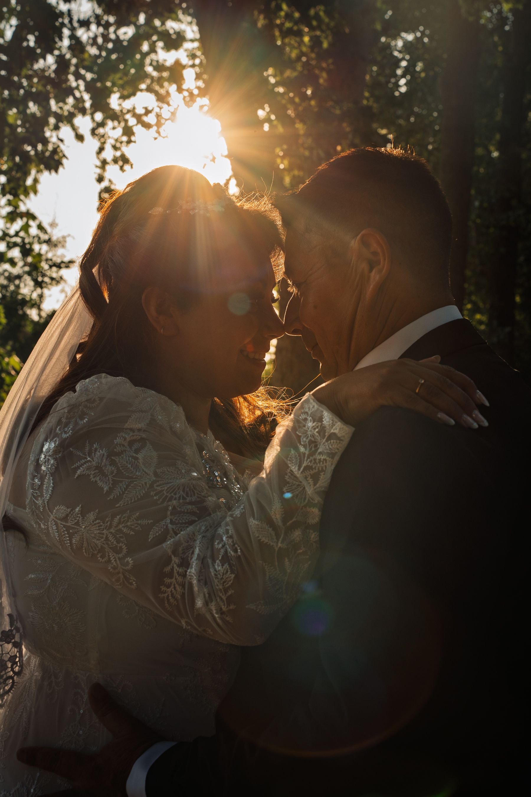 Pareja de novios besandose a contraluz durante el atardecer