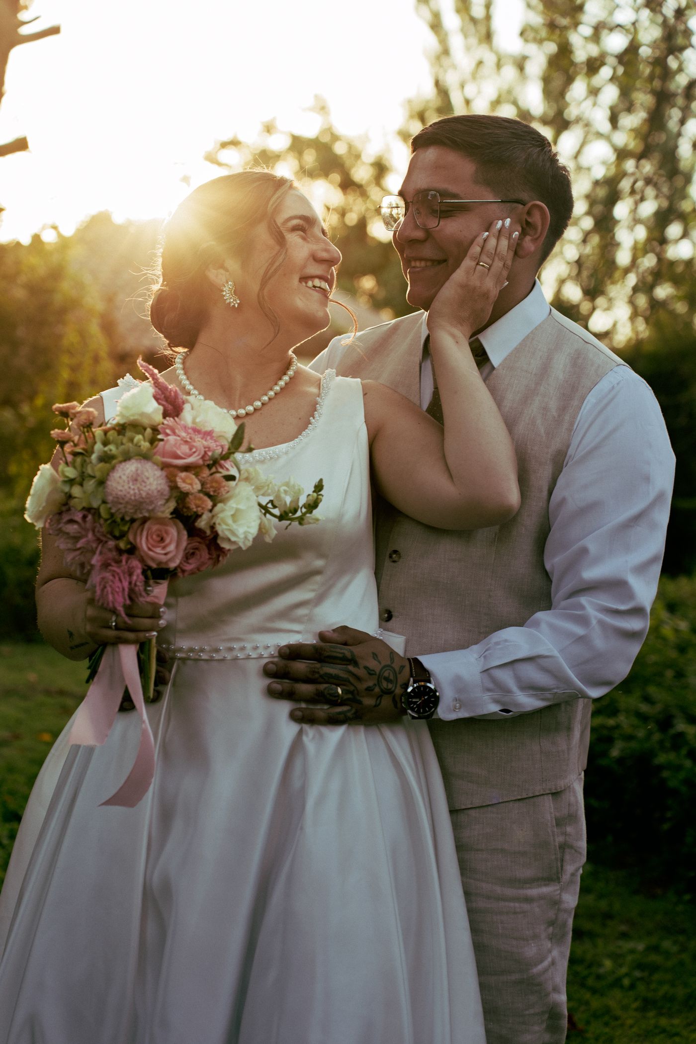 Los novios riendo mientras ella sostiene el ramo