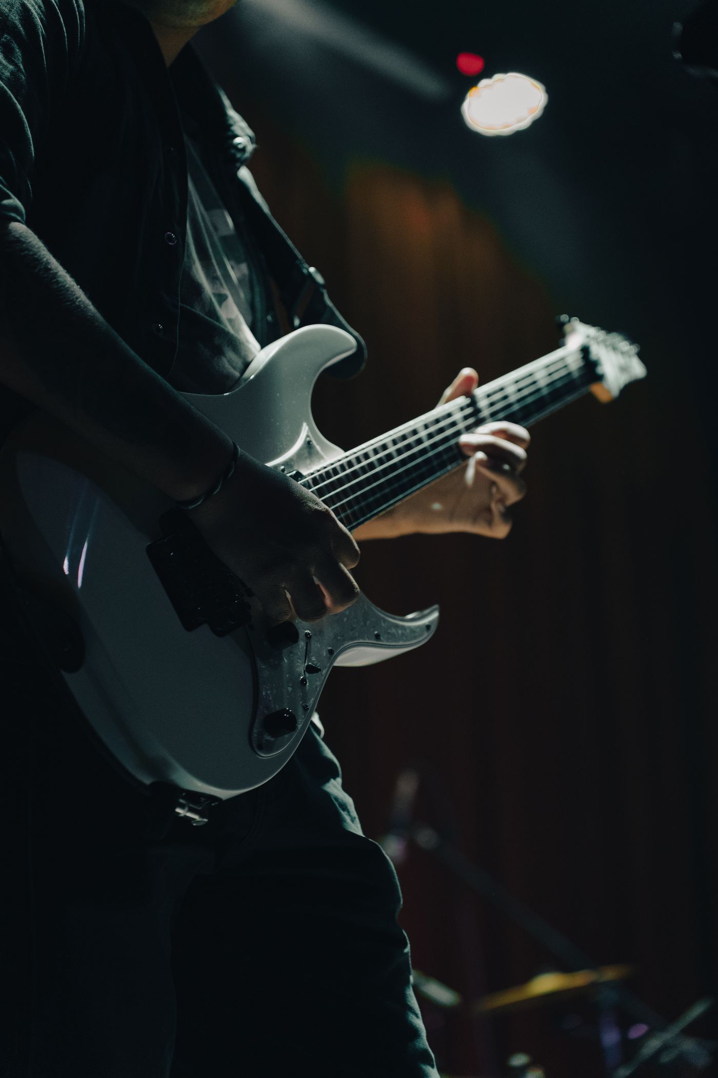 Guitarrista tocando un solo bajo un foco cenital