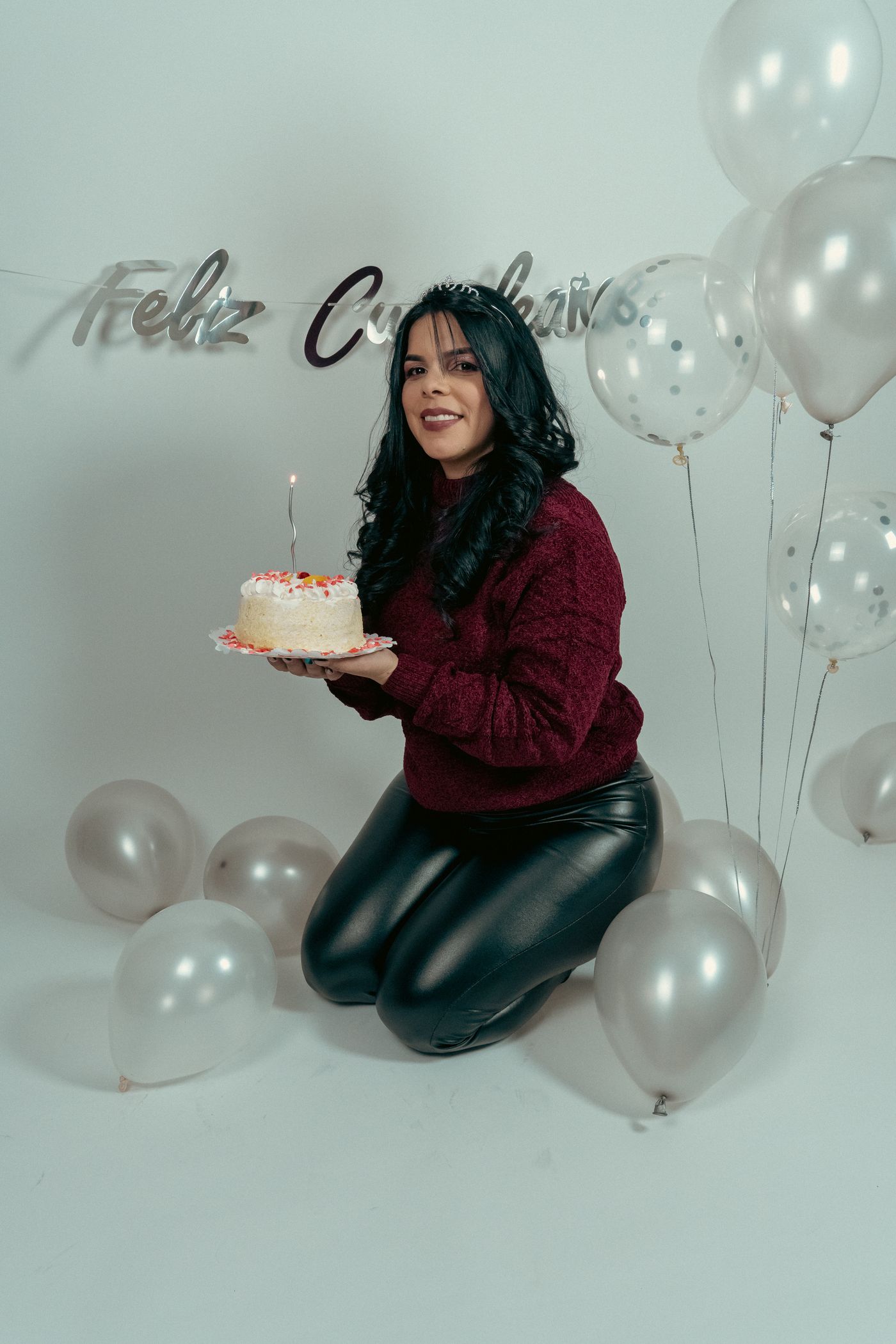 Mujer soplando la vela de su torta de cumpleaños en estudio