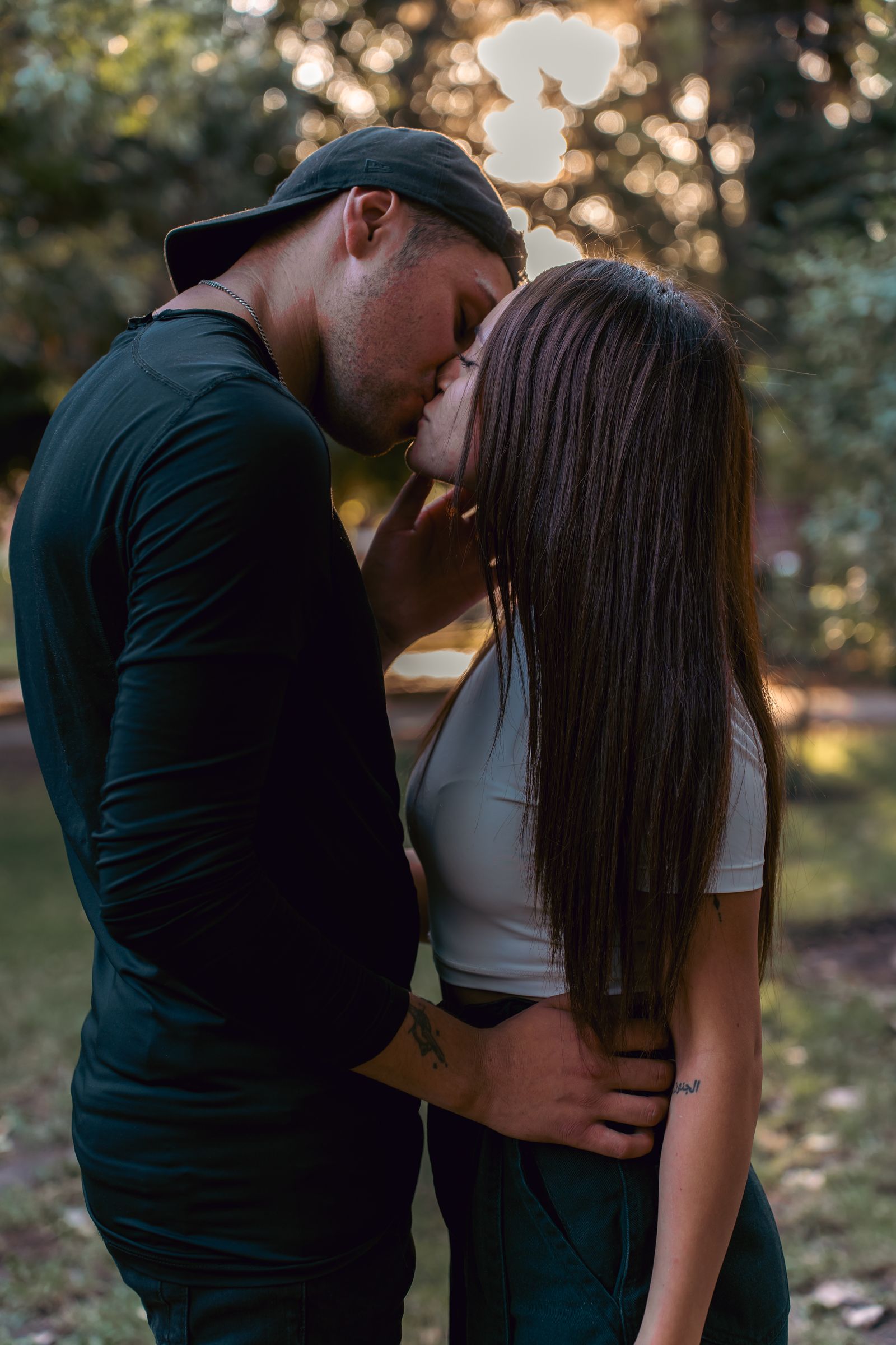 Pareja besandose en un parque durante la hora dorada