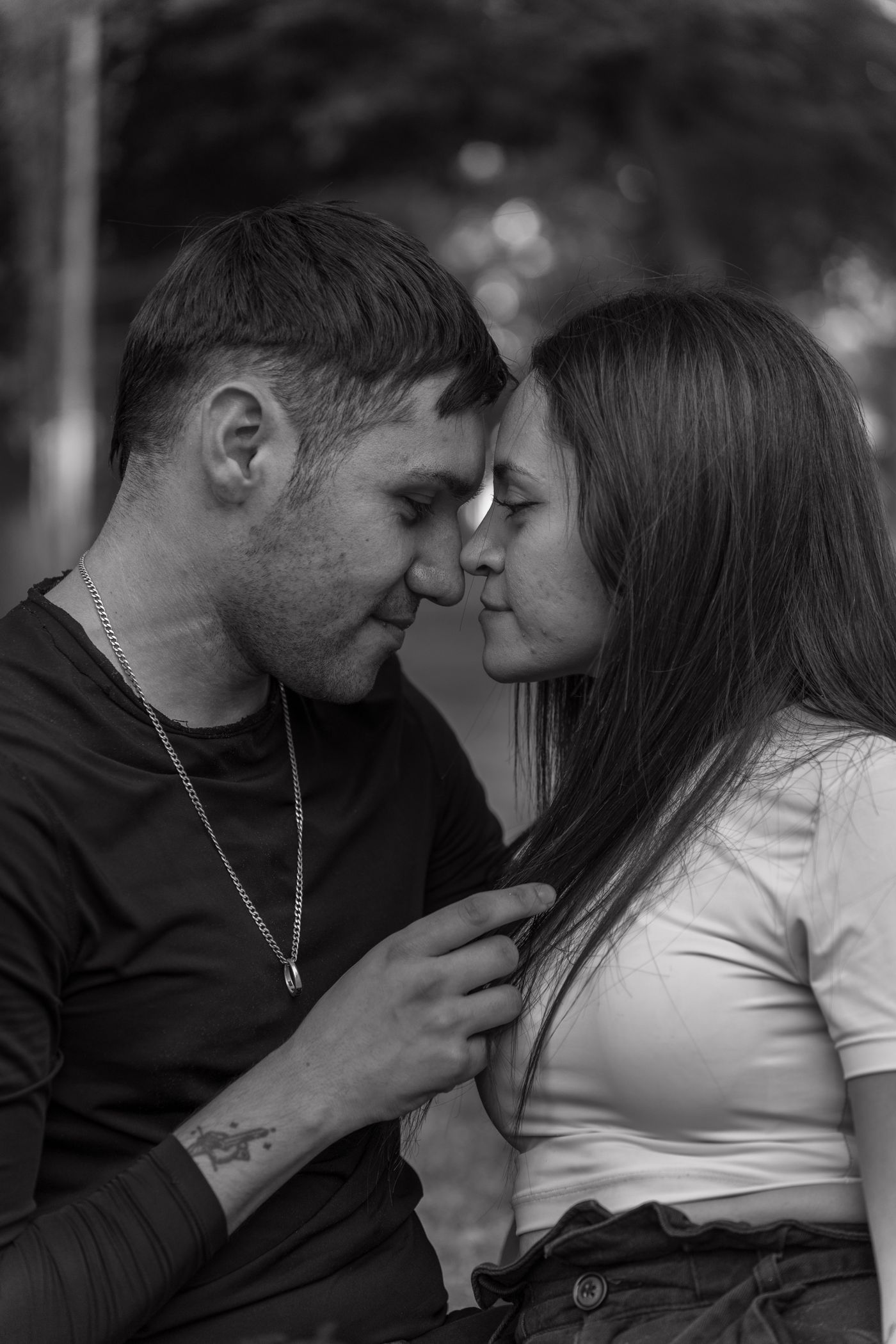 Pareja joven abrazada en un parque, fotografía en blanco y negro