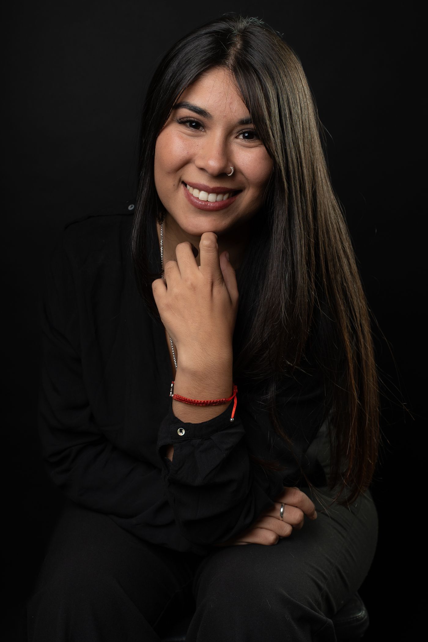 Retrato de estudio de una mujer sonriendo sobre fondo gris